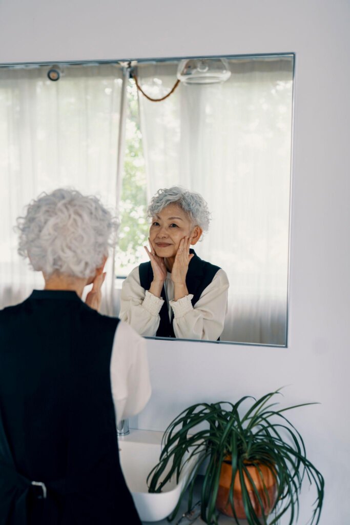 鏡を見ながら笑顔を見せる50代から60代の女性
